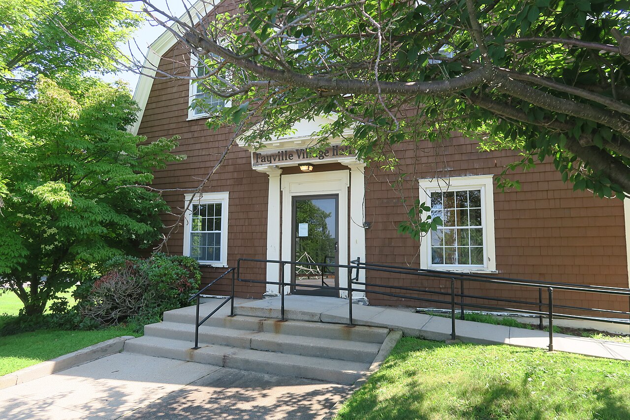 Front entrance of Fayville Village Hall, a brown-shingled building with a gambrel roof, white trim and concrete steps with railings