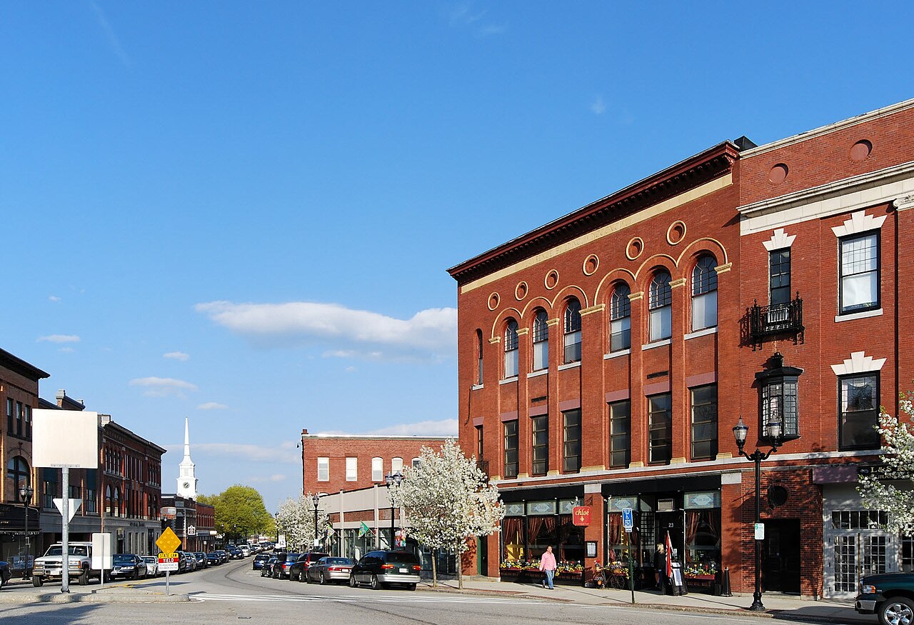 Brick commercial buildings and a church steeple along the main street in downtown Hudson