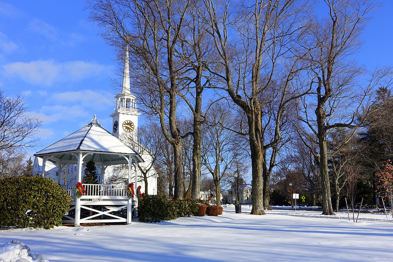 Shrewsbury town common in winter, with a white gazebo and a white church steeple behind bare trees