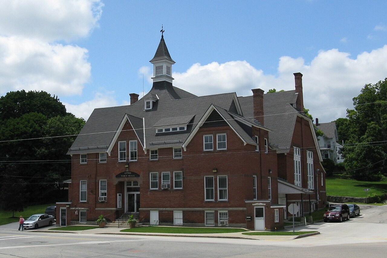 Upton Town Hall, a brick building with a white cupola and gabled roofline, seen from the street